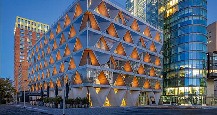 Das Bild zeigt das innovative Bürogebäude The Cradle, das als Meilenstein im Holzhybridbau und Vorreiter für nachhaltige Architektur und zirkuläre Wirtschaft gilt. 