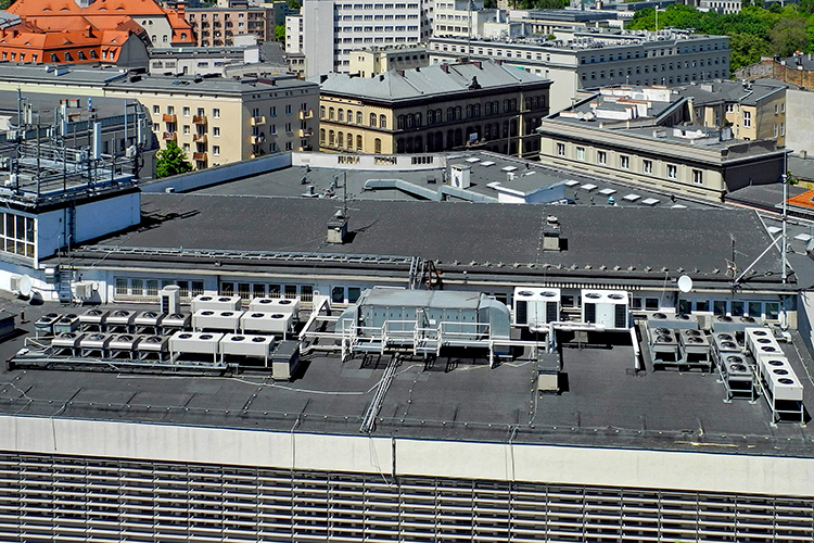 Das Bild zeigt eine Klimaanlage auf dem Dach eines Bürogebäudes. 