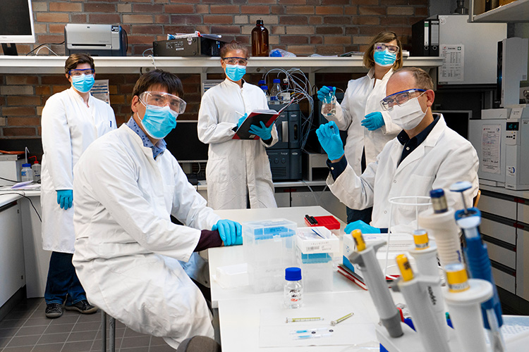 Prof. Dr. Stefan Kalkhof und Prof. Dr. Matthias Noll (sitzend) und ihr Team: Technikerin Viktoria Schyma und die Doktorandinnen Nadine Kiefer und Fabienne Reiß im Chemielabor der Hochschule Coburg (Foto: Simon Geistlinger, Hochschule Coburg) 