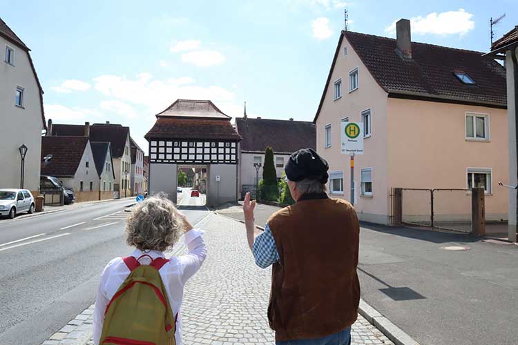 Blick auf den Eingang zum Ortskern der Gemeinde Uehlfeld: Prof. Dr. Jennifer Gerend (l.) und Stadtplaner Frieder Müller-Maatsch im Gespräch 