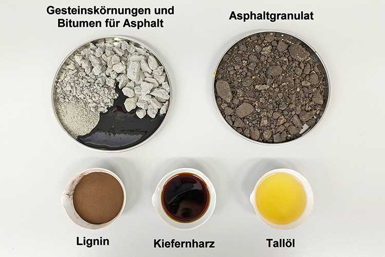 Das Bild zeigt die Bestandteile des herkömmlichen und des Bioasphalts: Gesteinskörnungen und Bitumen bzw. Asphaltgranulat, Lignin, Kiefernharz und Tallöl 