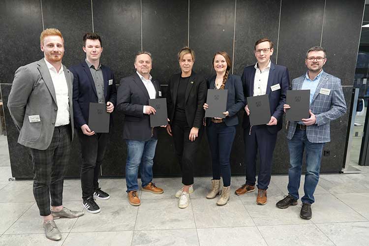 Wirtschafts- und Klimaschutzministerin Mona Neubaur (Mitte) und das Projektkonsortium:  (v. l.) Jannik Schlueer (Stadtwerk Verl), Robin Kreipe (Westfalen Weser Netz GmbH),  Prof. Dr.-Ing. Jens Haubrock (Hochschule Bielefeld), Carolin Pieper (Energie Impuls OWL e.V.),  Dr. Christoph Weskamp (Universität Paderborn) und Frank Höwelhasse (Stadtwerk Verl) 