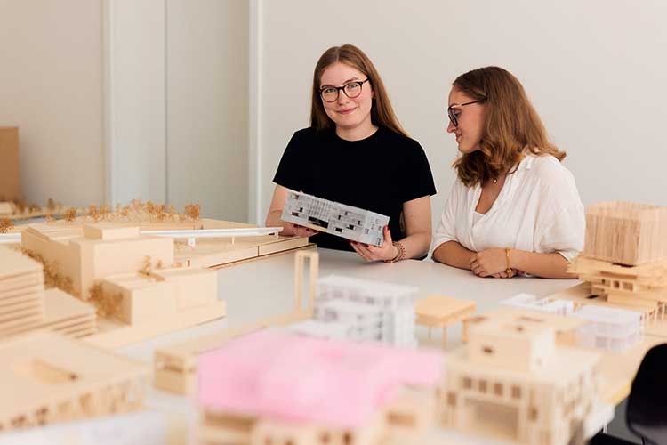 Anne-Marie Fink (l.) und Charlotte Gehlen (r.) mit ihrem Modell des Studierendenwohnheims 