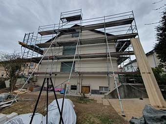 Das Bild zeigt das noch ungedämmte, eingerüstete Gebäude  in Esslingen-Berkheim mit bereits demontierten Fenstern. 
