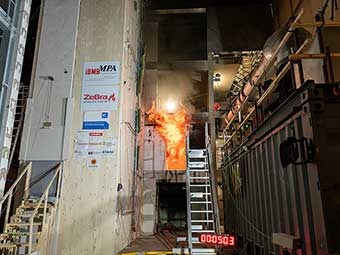 Versuchsaufbau zur Brandschutzprüfung. Ein intensives Feuer lodert in einem Testbereich. 